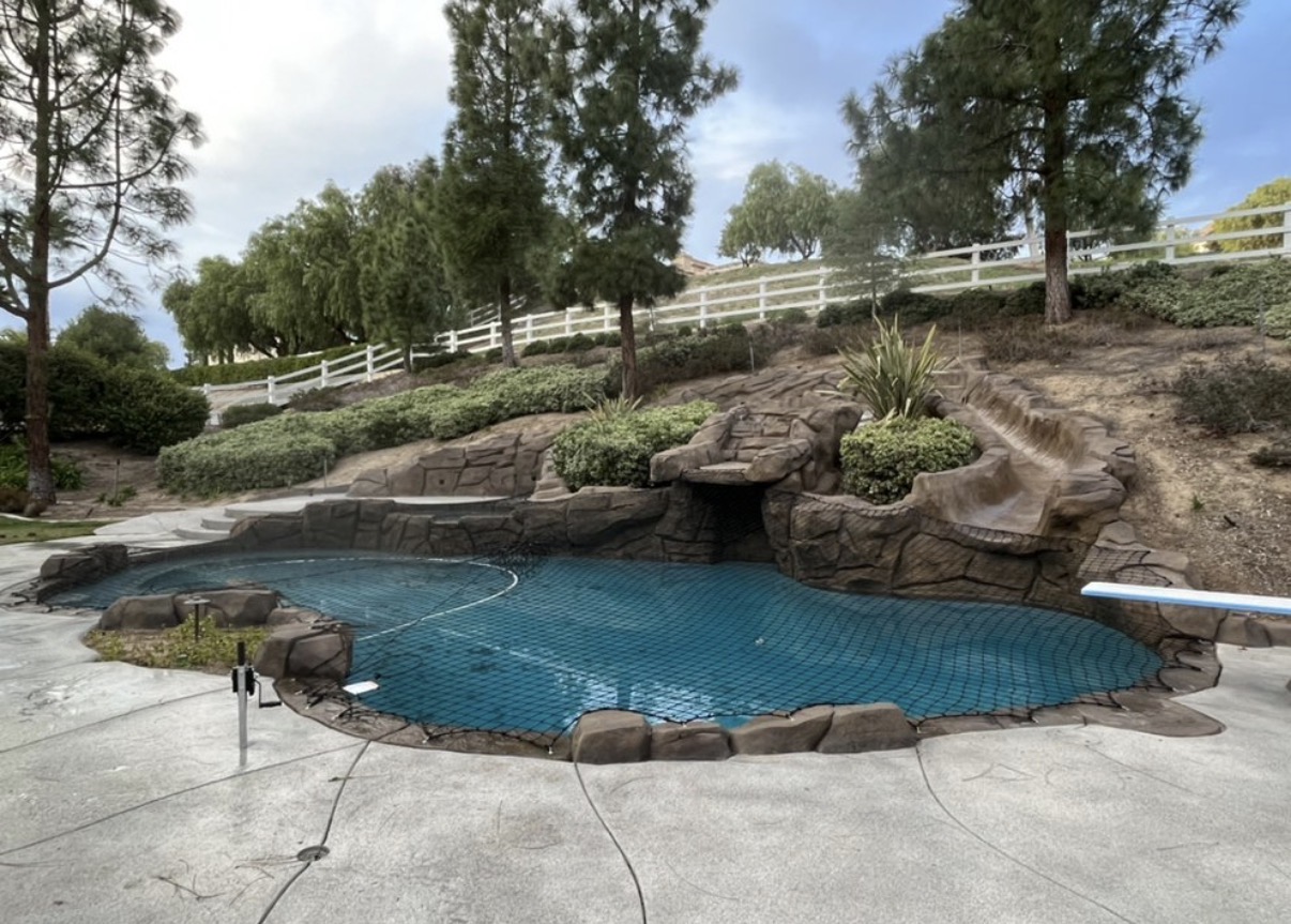 Rock waterfall pool with safety net