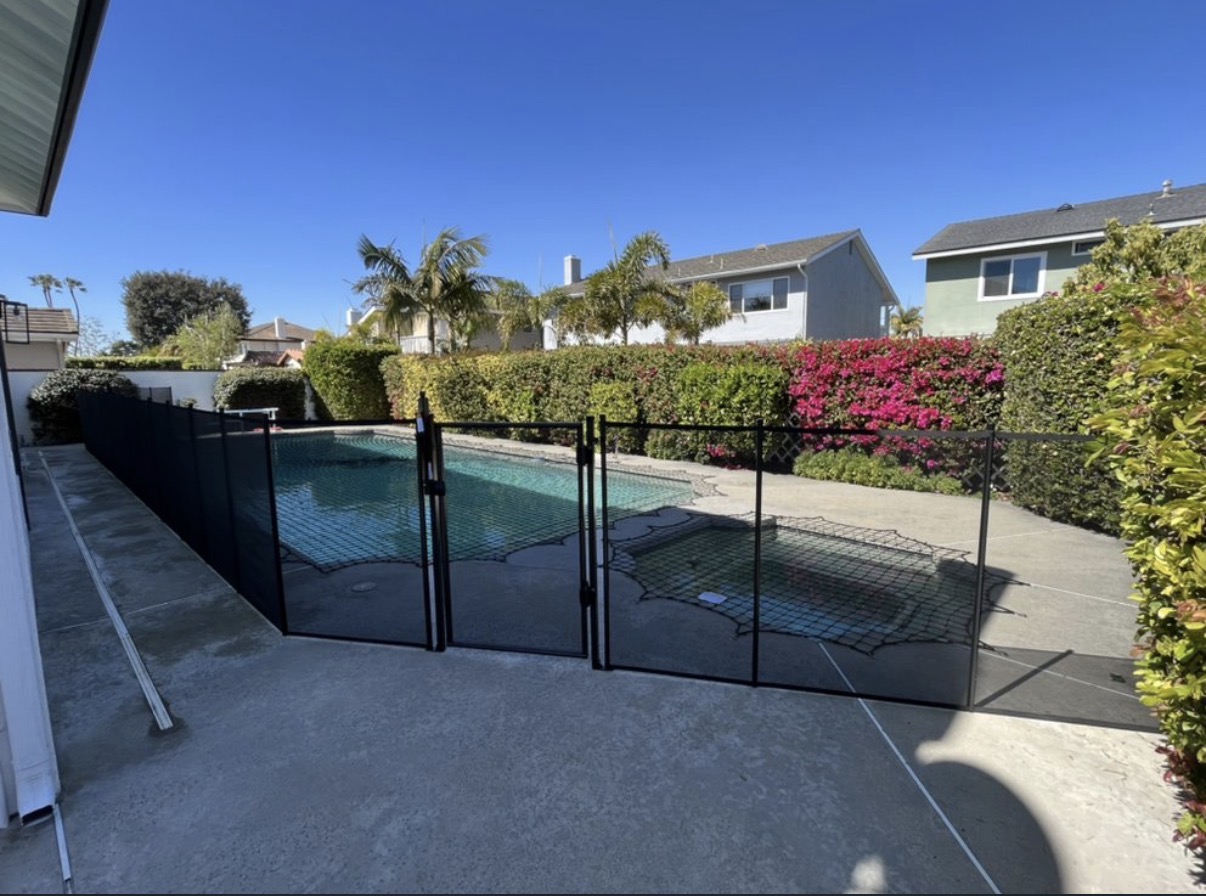 Backyard pool with black mesh fence and gate