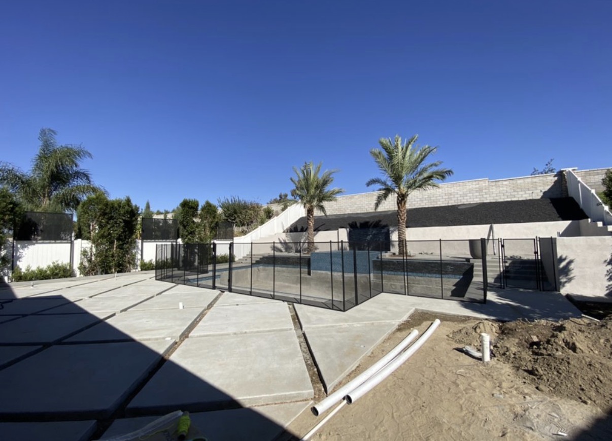 Modern pool with palm trees and safety fence