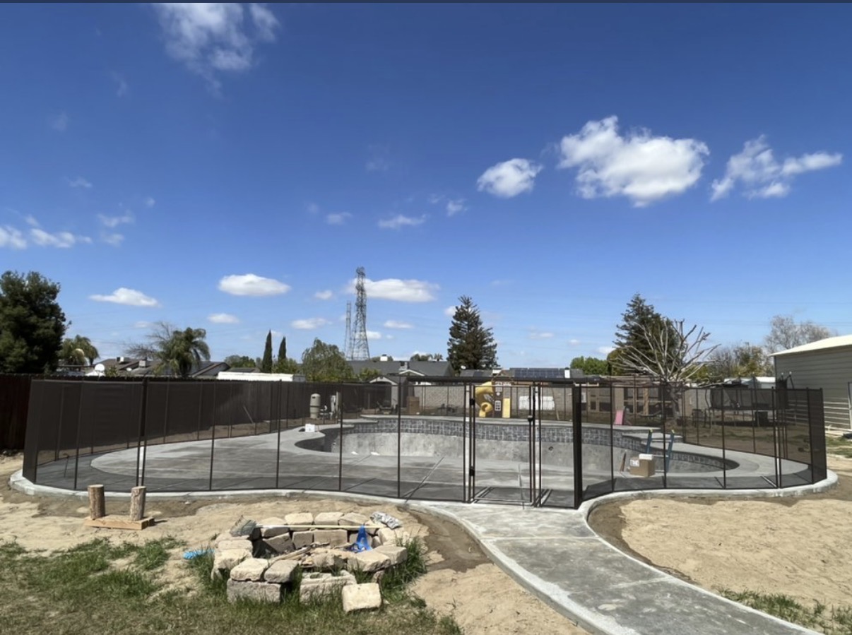 New construction pool with black safety fence