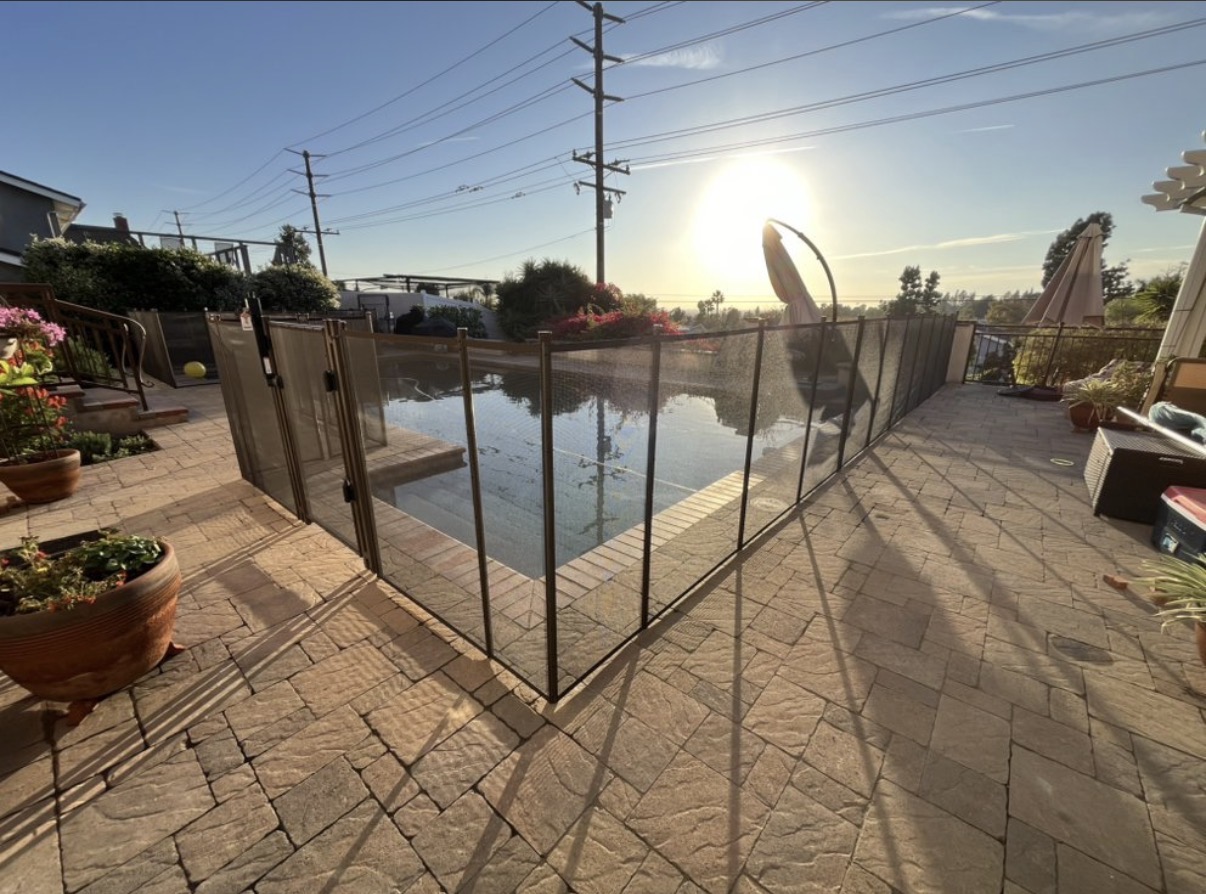 Sunset view of pool with brown mesh safety fence